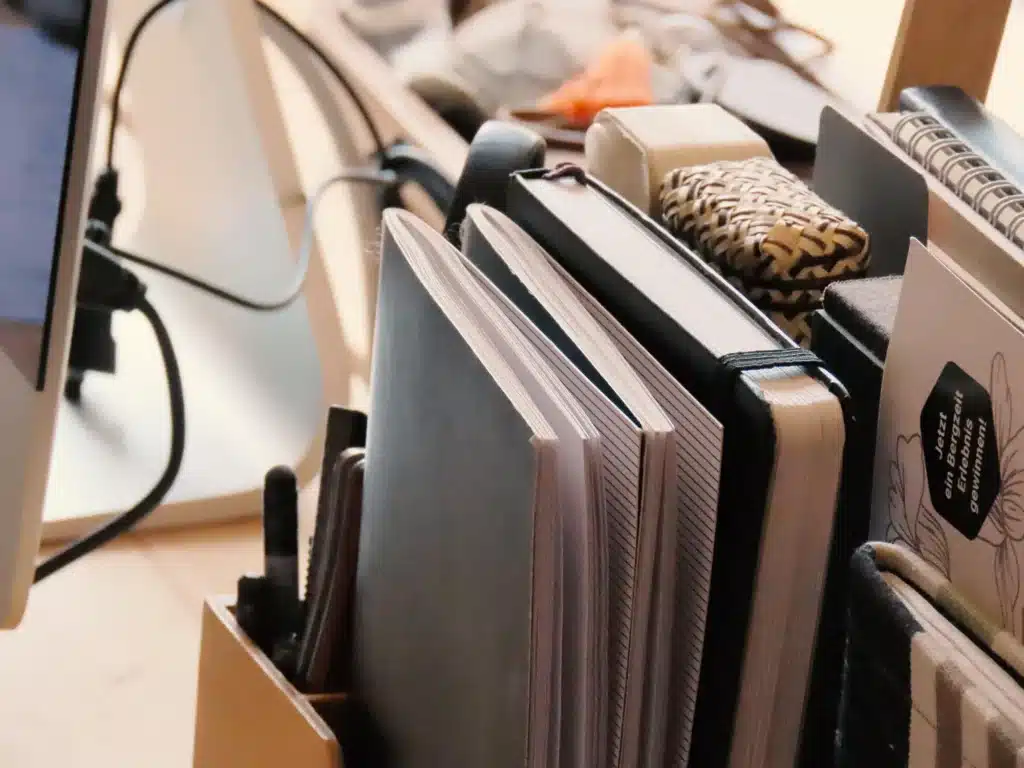 Arbeitspaltz der pixelsymbiose. Notizbücher stehen in einem Organizer auf dem Schreibtisch.